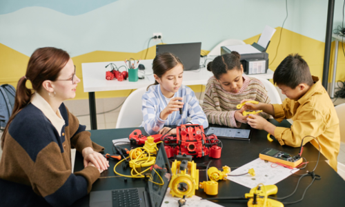 Group of children actively engaging in STEM activities under the supervision of educator