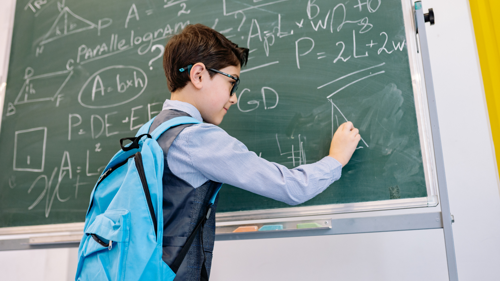 Student solves a math problem on a classroom chalkboard