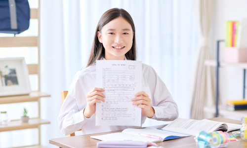 Student holding up a test paper with a good grade